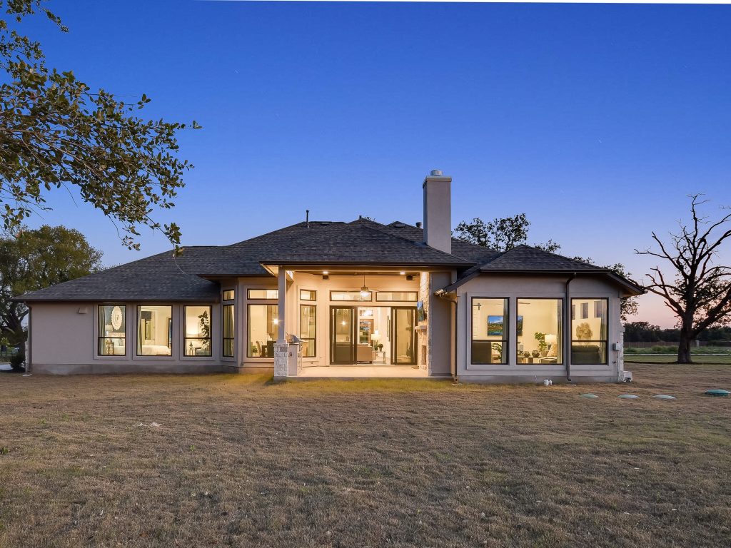 Exterior view of custom home with large windows at sunset