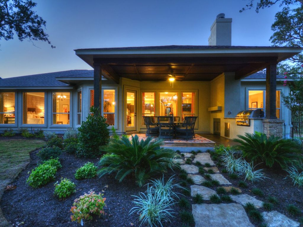 Exterior view of Giddens custom home at sunset with landscaped lawn and custom design features