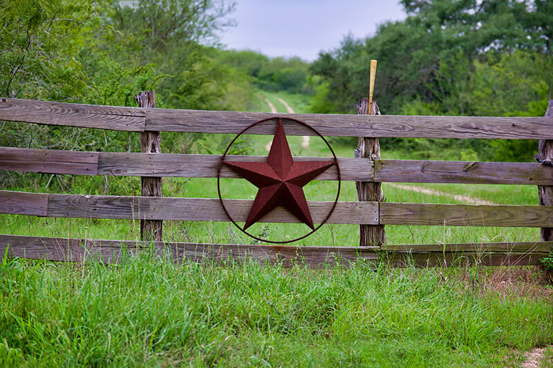 Wooden fence with metal Texas star symbol on a Liberty Hill ranch property