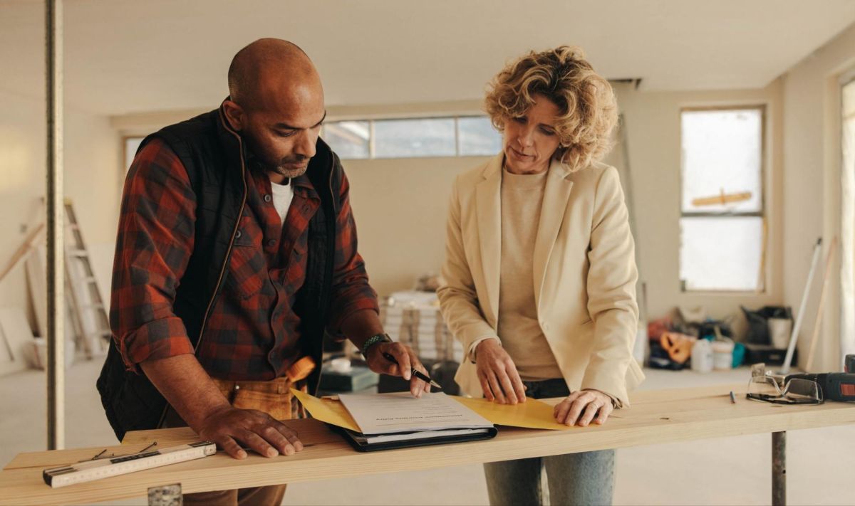 Image of two people signing a contract inside a home.